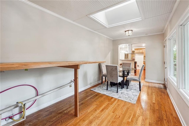 dining area with light hardwood / wood-style flooring and crown molding