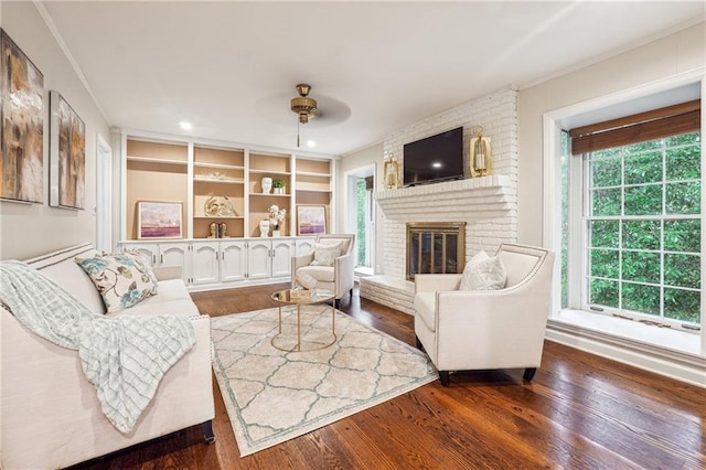 living room featuring dark hardwood / wood-style floors, a healthy amount of sunlight, and a brick fireplace