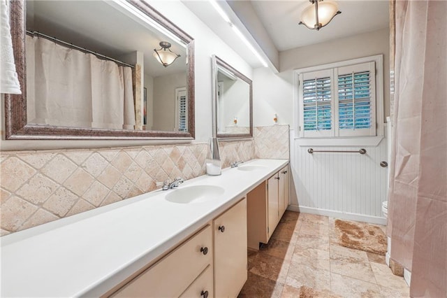 bathroom featuring vanity, toilet, and tasteful backsplash