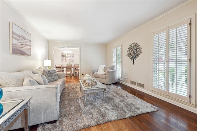 living room featuring crown molding, wood-type flooring, and a notable chandelier