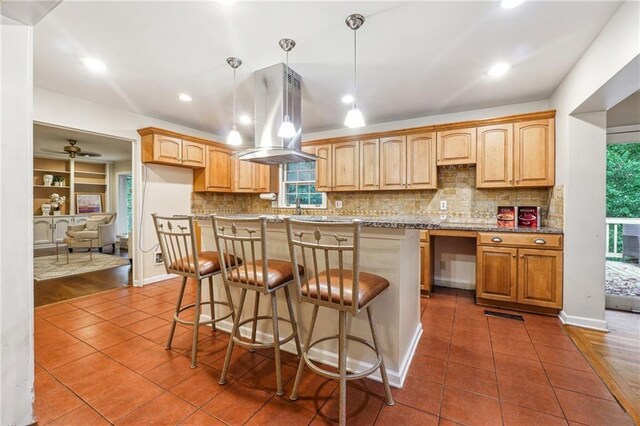 kitchen with pendant lighting, dark hardwood / wood-style floors, island range hood, and decorative backsplash