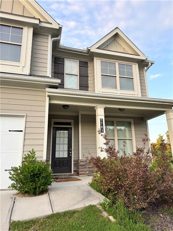7703 Hansel Ln, Lithonia, GA 30058 - property entrance with covered porch, board and batten siding, and a garage
