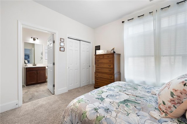 carpeted bedroom featuring a closet and ensuite bath