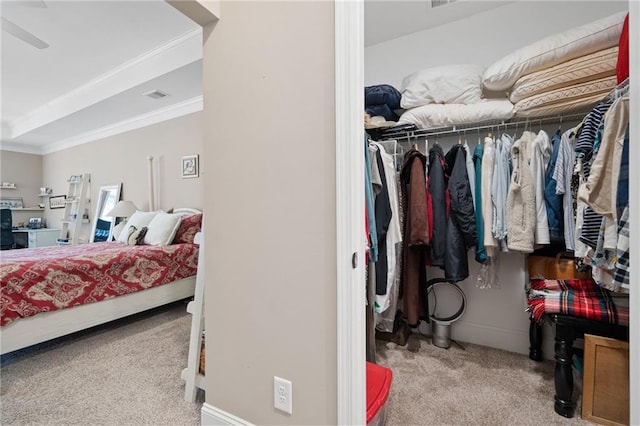 carpeted bedroom with a closet, ornamental molding, and ceiling fan