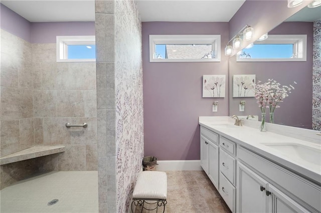 bathroom with vanity, plenty of natural light, and a tile shower