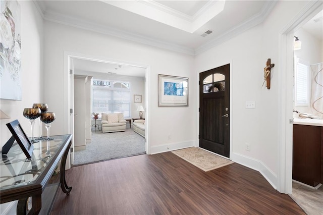 foyer featuring a tray ceiling, crown molding, and hardwood / wood-style floors