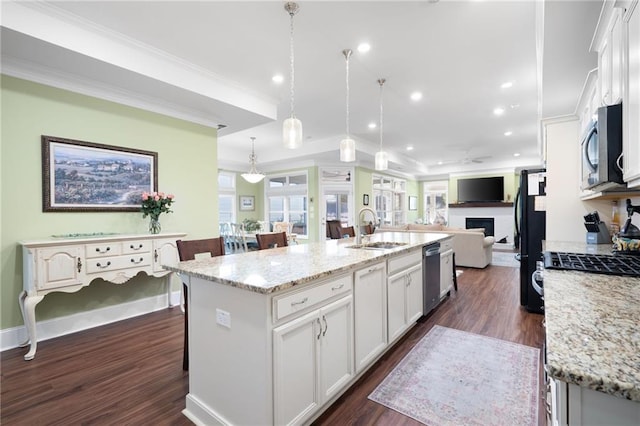 kitchen featuring sink, white cabinetry, hanging light fixtures, an island with sink, and stainless steel appliances