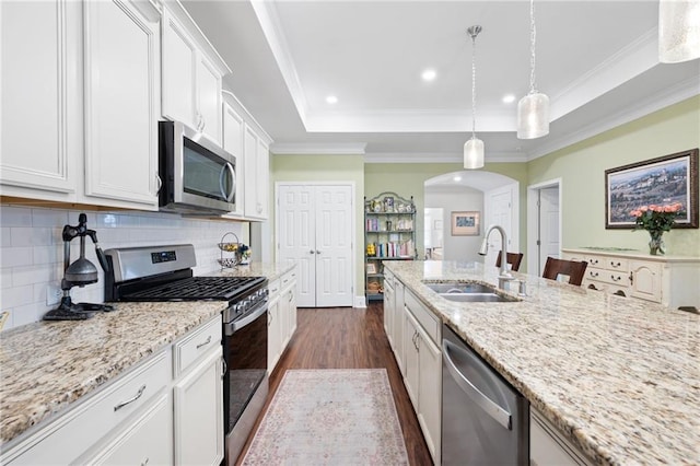 kitchen featuring white cabinets, appliances with stainless steel finishes, sink, and pendant lighting