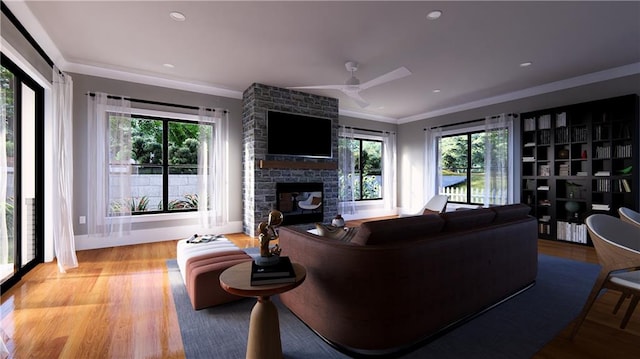 living room with light hardwood / wood-style floors, a healthy amount of sunlight, and a stone fireplace