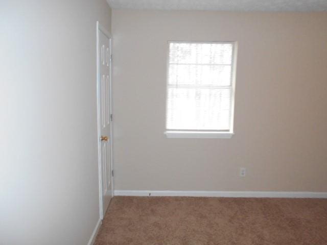 spare room with carpet floors and baseboards