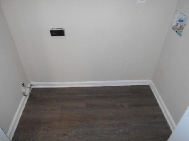 clothes washing area featuring dark wood finished floors and baseboards