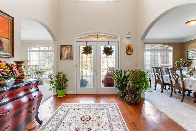 foyer entrance featuring french doors, light wood-type flooring, and ornamental molding