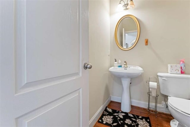 bathroom with hardwood / wood-style flooring and toilet