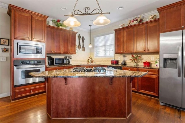 kitchen featuring a kitchen island, hanging light fixtures, dark hardwood / wood-style floors, and appliances with stainless steel finishes