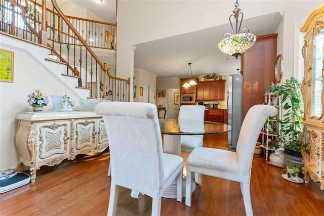 dining area featuring hardwood / wood-style floors and a high ceiling