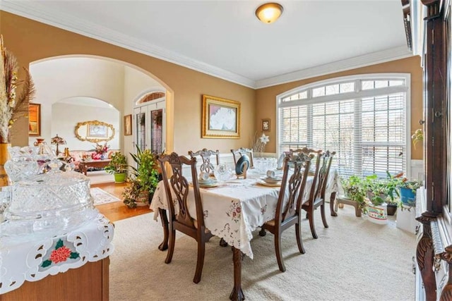 carpeted dining area featuring ornamental molding