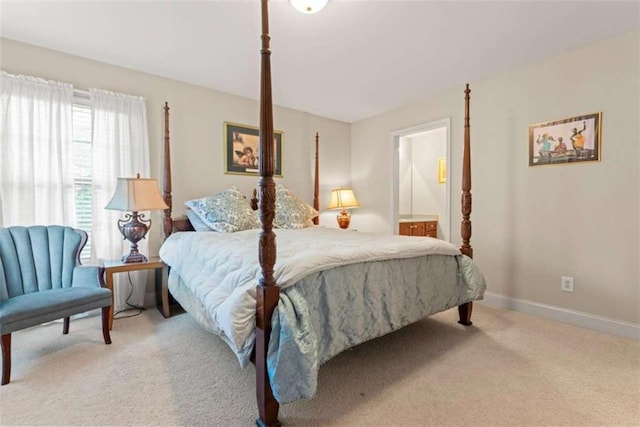 bedroom with connected bathroom and light colored carpet