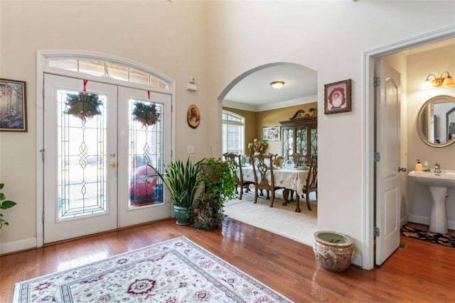 foyer entrance with french doors, hardwood / wood-style flooring, ornamental molding, and sink