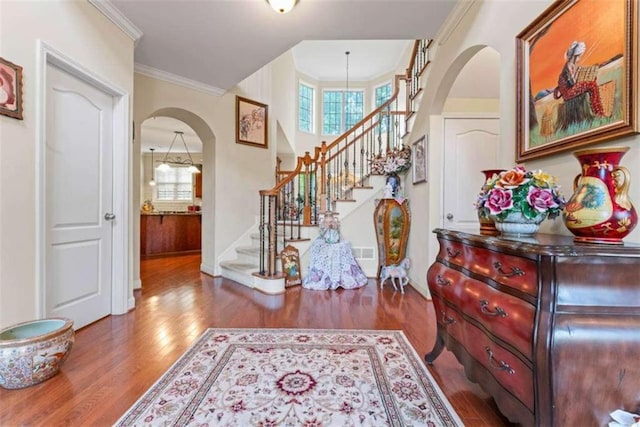 entrance foyer featuring crown molding and wood-type flooring