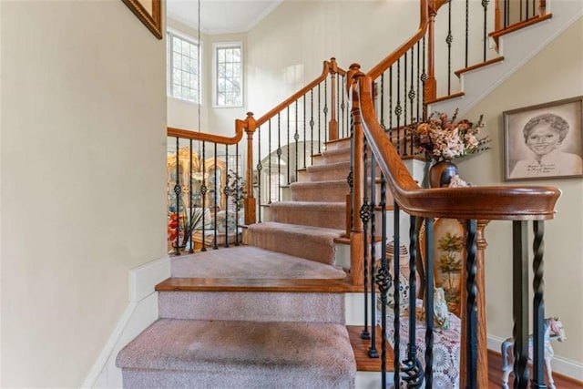 stairs with crown molding and wood-type flooring