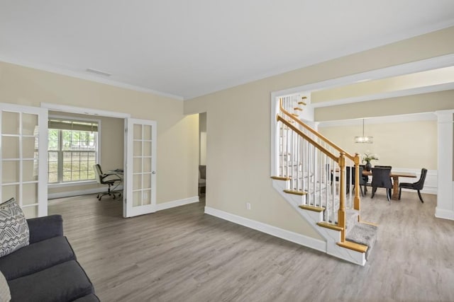 1465 Laleiah Dr, Cumming, GA 30041 - living area with french doors, crown molding, wood finished floors, stairway, and a chandelier