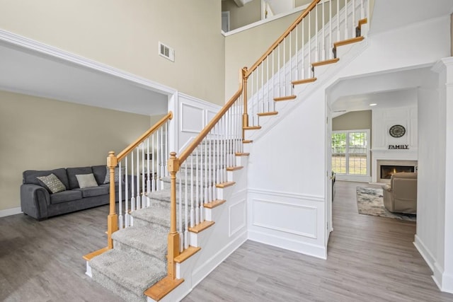 1465 Laleiah Dr, Cumming, GA 30041 - staircase featuring a high ceiling, wood finished floors, and visible vents