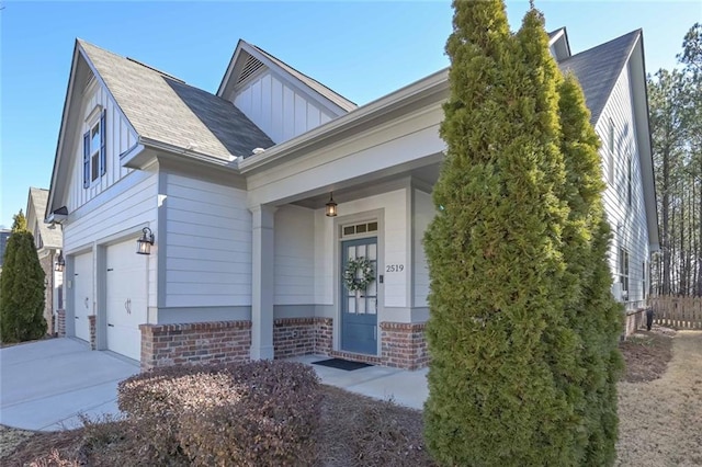 view of front of property featuring brick siding, board and batten siding, a porch, driveway, and an attached garage