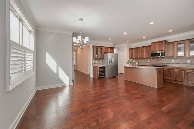 kitchen with decorative light fixtures, appliances with stainless steel finishes, dark hardwood / wood-style flooring, a kitchen island, and decorative backsplash