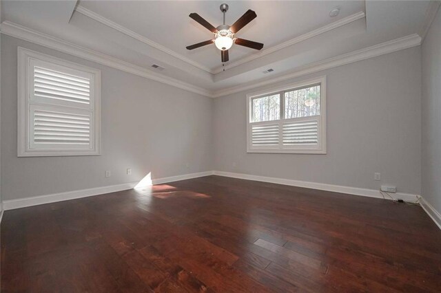 empty room featuring dark wood-type flooring, ceiling fan, crown molding, and a raised ceiling