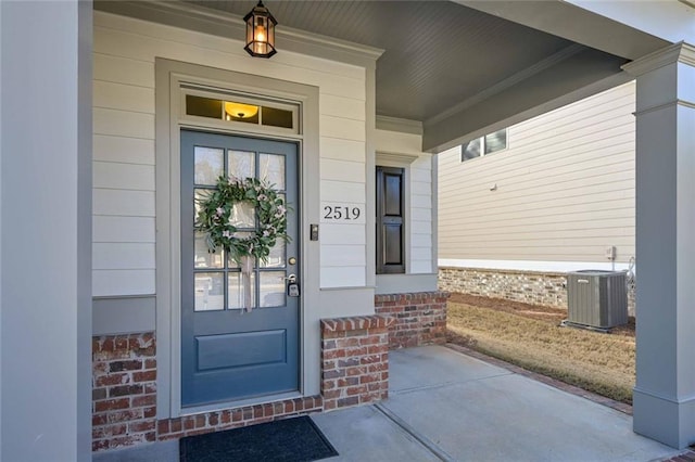 doorway to property featuring covered porch and central AC unit