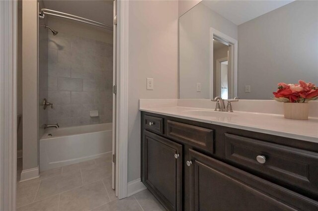 bathroom with tile patterned flooring, vanity, and tiled shower / bath combo