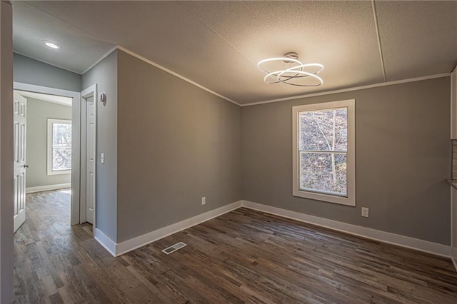 unfurnished dining area with dark wood finished floors, baseboards, visible vents, and ornamental molding