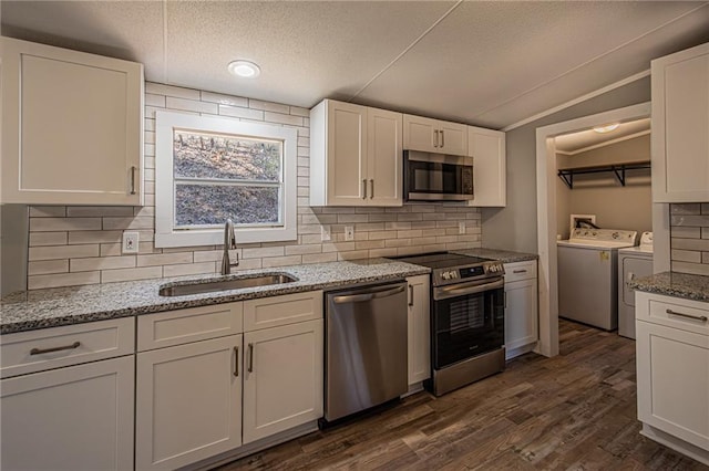 kitchen featuring dark wood-style floors, separate washer and dryer, a sink, appliances with stainless steel finishes, and white cabinetry