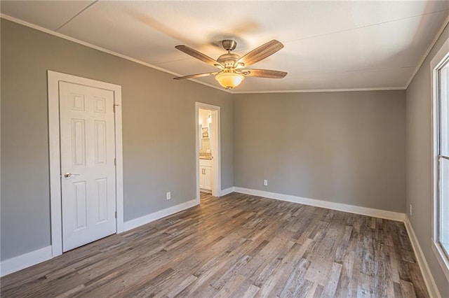 unfurnished bedroom featuring ceiling fan, wood finished floors, baseboards, and ornamental molding