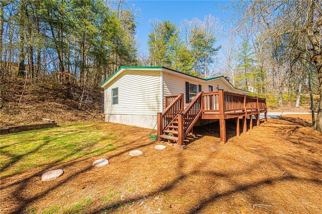 view of side of property featuring a lawn and a wooden deck