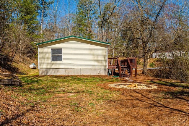 view of home's exterior with stairway, a lawn, and a wooden deck