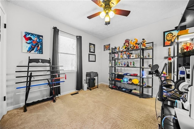 interior space with visible vents, baseboards, a ceiling fan, carpet, and a textured ceiling