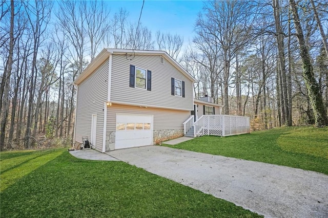 view of side of property featuring driveway, stone siding, a garage, and a yard