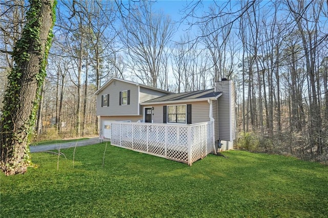 view of property exterior with a garage, driveway, a yard, and a chimney