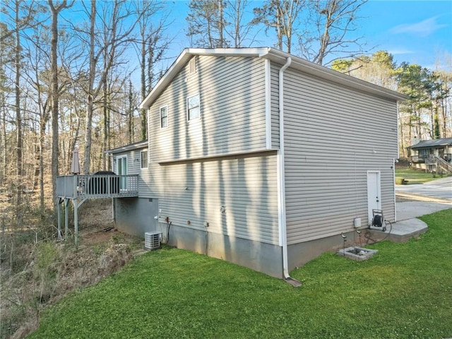 view of side of home with a deck and a yard