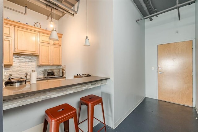 120 Ralph Mcgill Blvd NE Unit 1502, Atlanta, GA 30308 - kitchen featuring a towering ceiling, decorative backsplash, concrete flooring, a breakfast bar area, and light brown cabinets