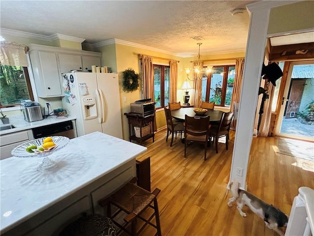 kitchen featuring decorative light fixtures, light hardwood / wood-style floors, white refrigerator with ice dispenser, a notable chandelier, and ornamental molding