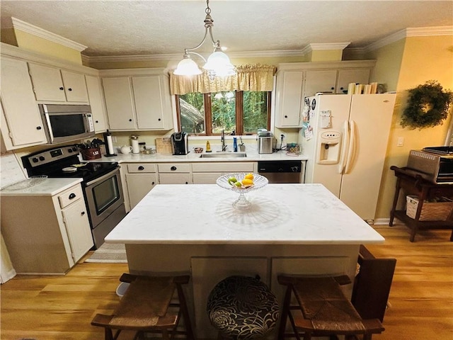 kitchen featuring a center island, light hardwood / wood-style floors, stainless steel appliances, and hanging light fixtures