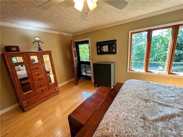 bedroom featuring ceiling fan, hardwood / wood-style flooring, ornamental molding, and a textured ceiling