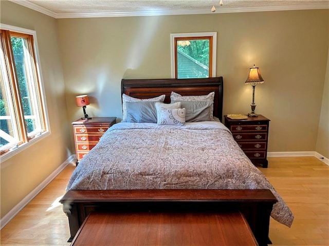 bedroom featuring crown molding, multiple windows, and hardwood / wood-style floors