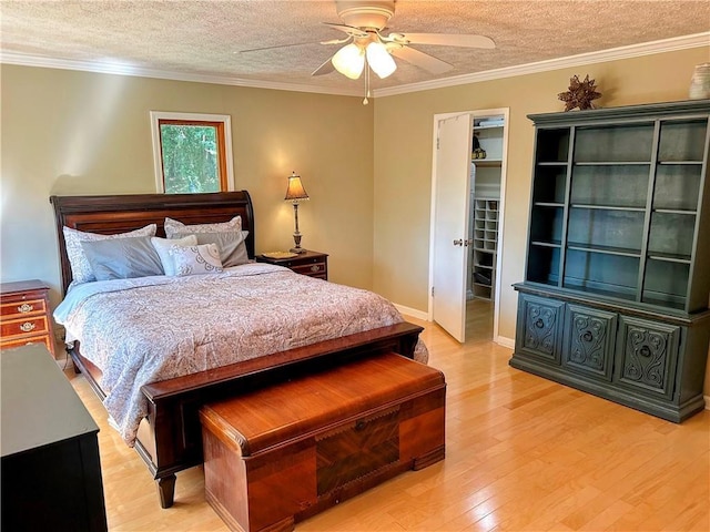 bedroom featuring ceiling fan, ornamental molding, light hardwood / wood-style floors, and a textured ceiling