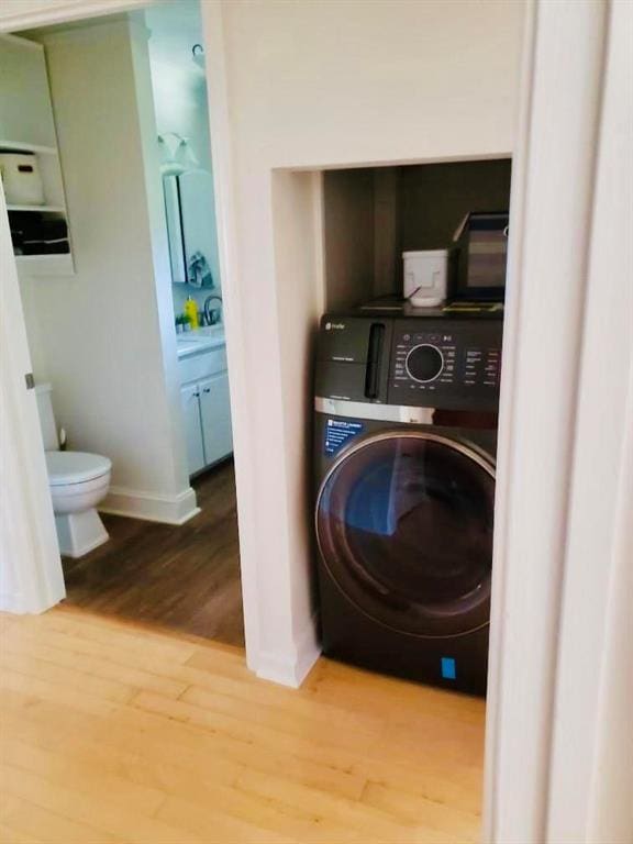 laundry room with washer / dryer and light hardwood / wood-style floors