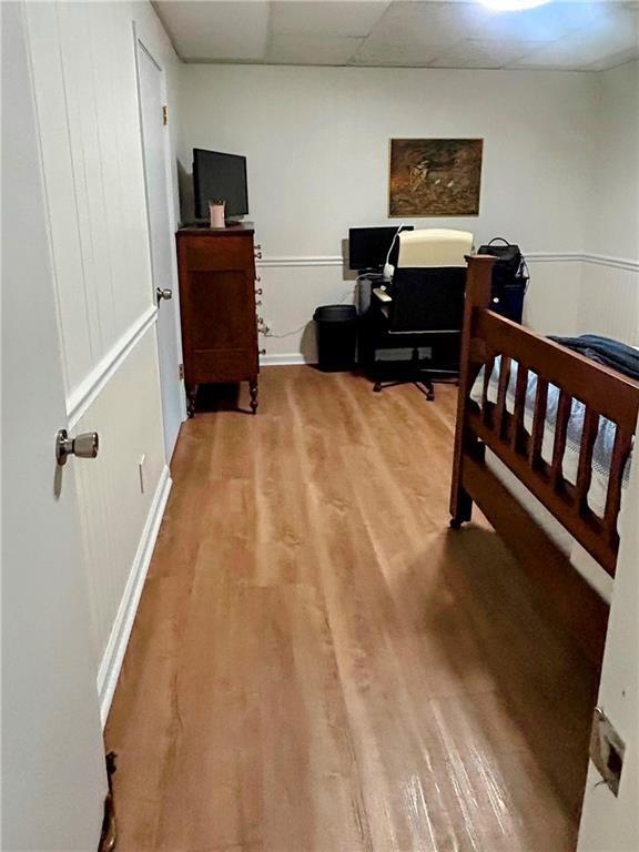 bedroom featuring hardwood / wood-style flooring and a paneled ceiling