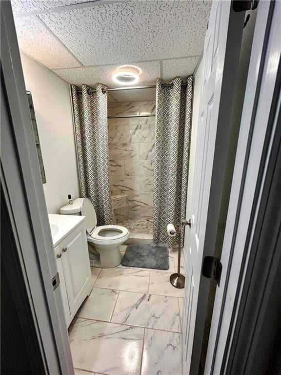 bathroom featuring vanity, toilet, a shower with shower curtain, and a drop ceiling