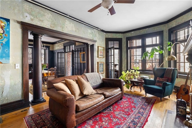 living room with wood-type flooring, decorative columns, and a healthy amount of sunlight